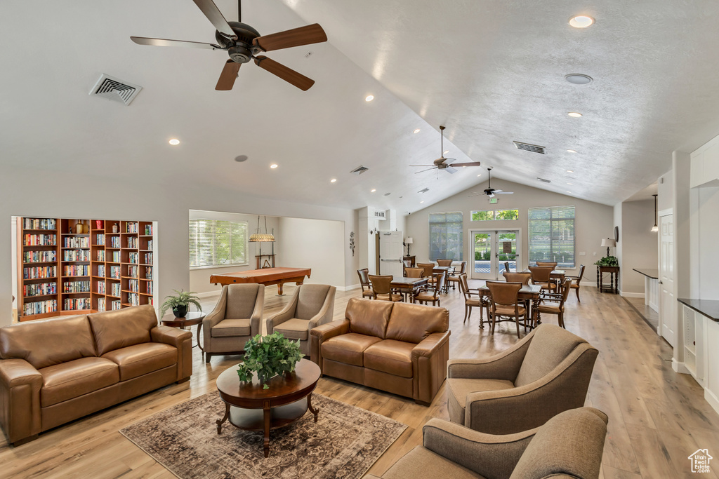 Living room featuring visible vents, a ceiling fan, vaulted ceiling, and a wealth of natural light