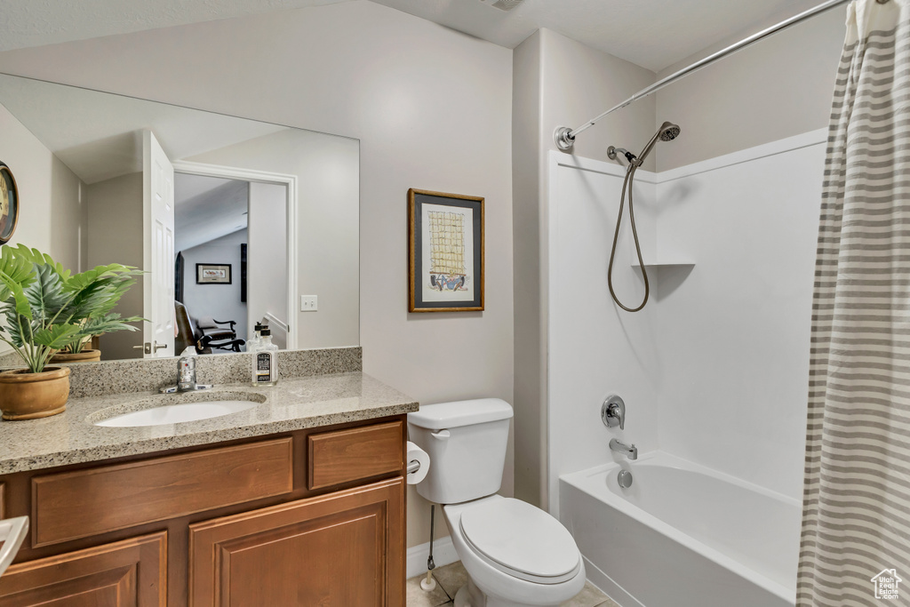 Bathroom with vanity, tile patterned floors, shower / bath combo, and toilet