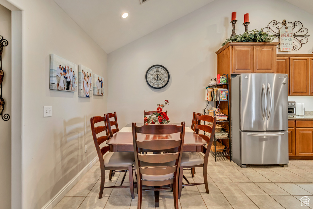 Dining area with light tile patterned floors, recessed lighting, and lofted ceiling