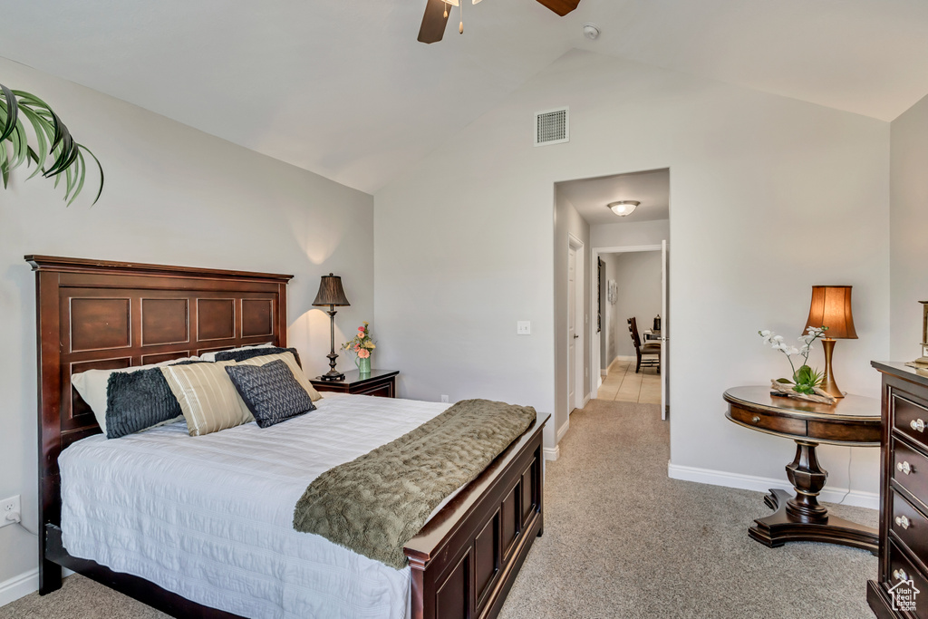 Bedroom with visible vents, baseboards, high vaulted ceiling, and light colored carpet