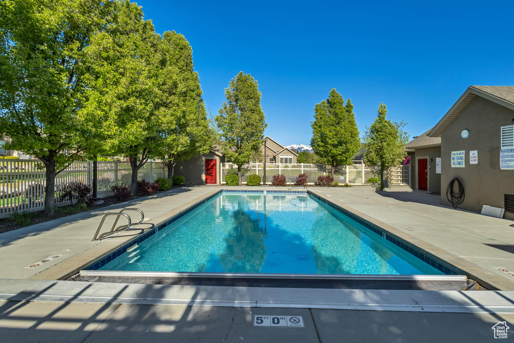 Community pool featuring a patio and fence