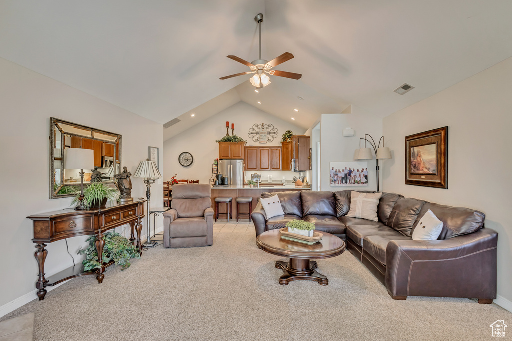 Living area with ceiling fan, light carpet, baseboards, and lofted ceiling