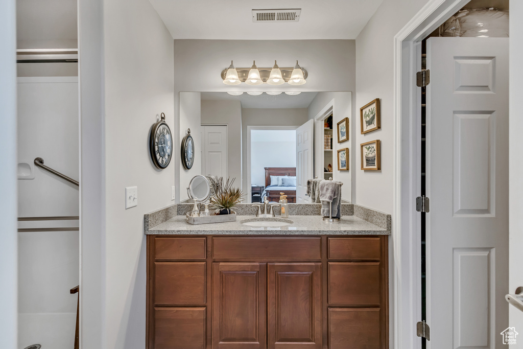 Bathroom with vanity, visible vents, and ensuite bath
