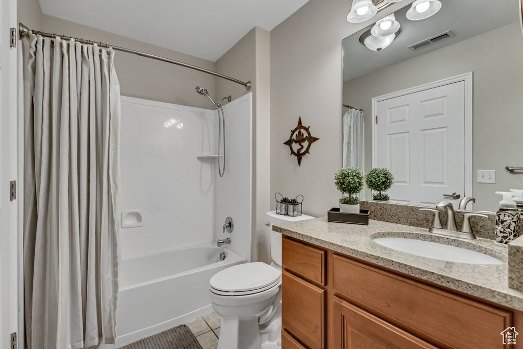 Bathroom with visible vents, tile patterned floors, vanity, toilet, and shower / bath combo with shower curtain