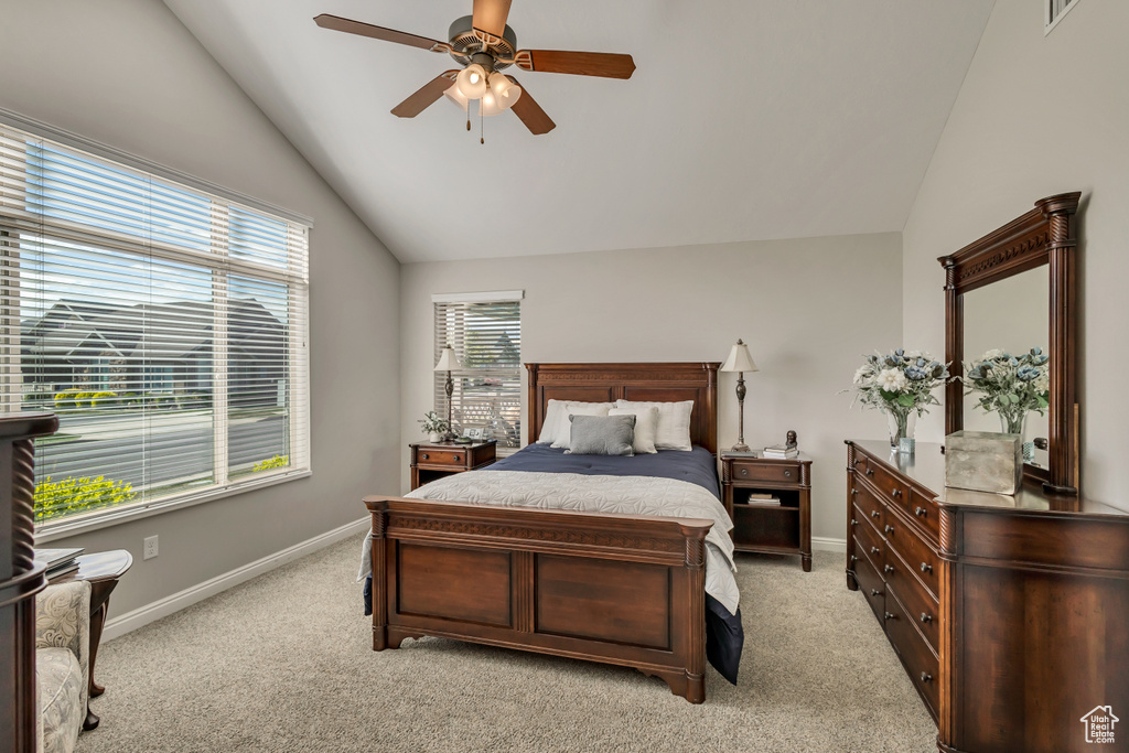 Bedroom featuring baseboards, light carpet, a ceiling fan, and lofted ceiling
