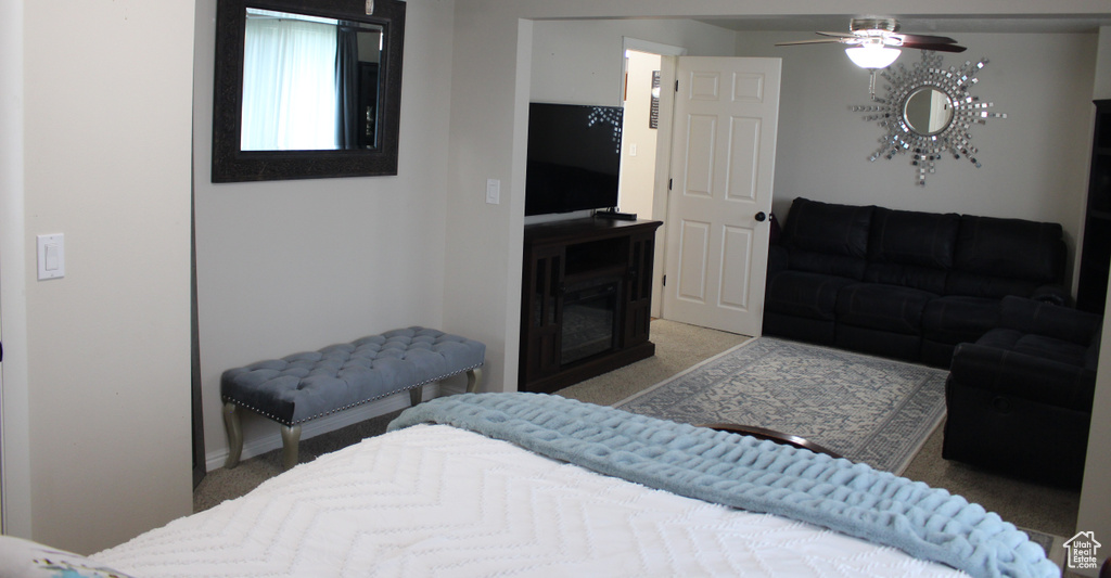 Bedroom featuring baseboards, a fireplace, and light colored carpet