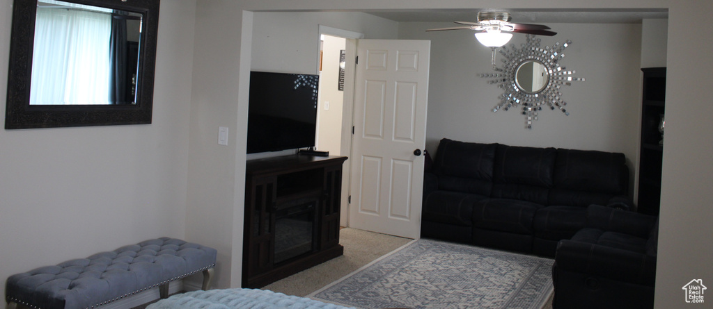 Living area featuring ceiling fan and light colored carpet