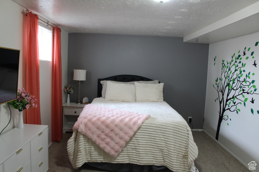Carpeted bedroom with baseboards and a textured ceiling