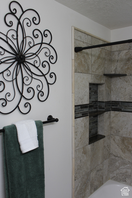 Full bathroom with a bath, walk in shower, and a textured ceiling