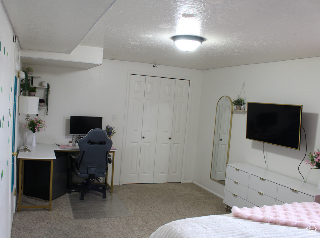 Carpeted bedroom with a closet and a textured ceiling