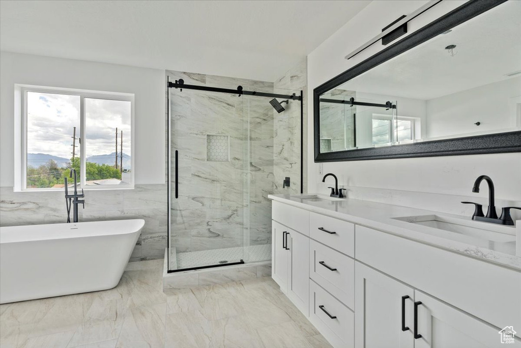 Full bathroom with a sink, a marble finish shower, and a freestanding tub