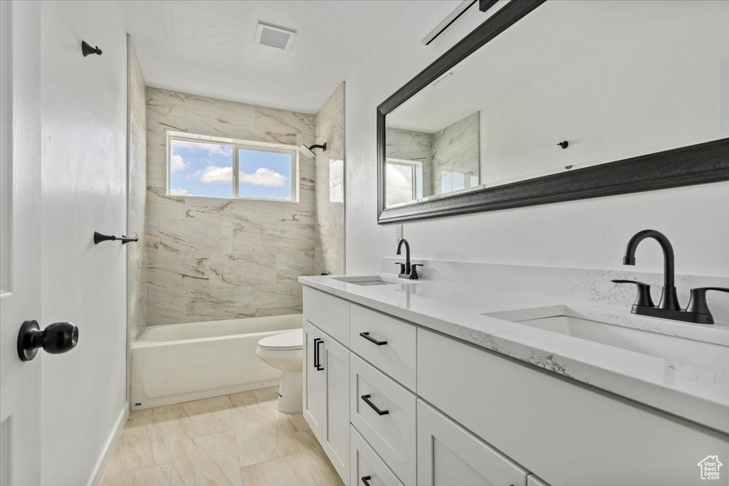 Full bathroom with double vanity, a sink, marble finish floor, and toilet