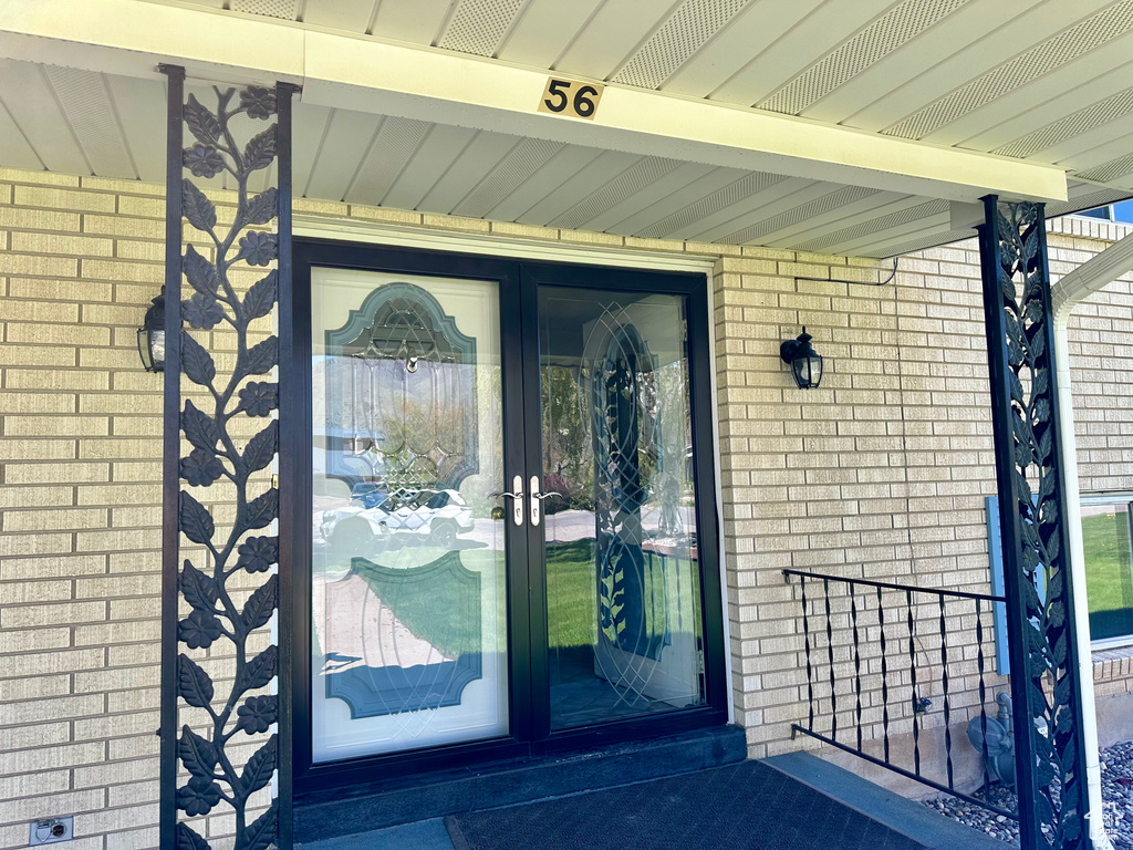 Entrance to property featuring french doors and brick siding