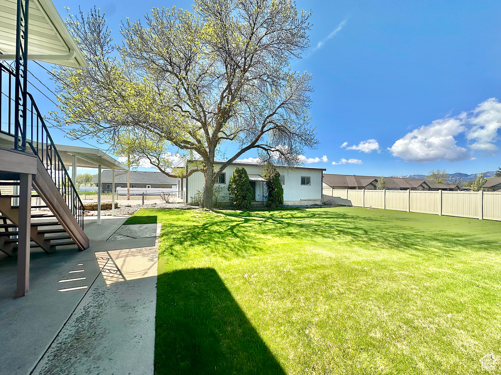 View of yard with a patio, fence, and stairway
