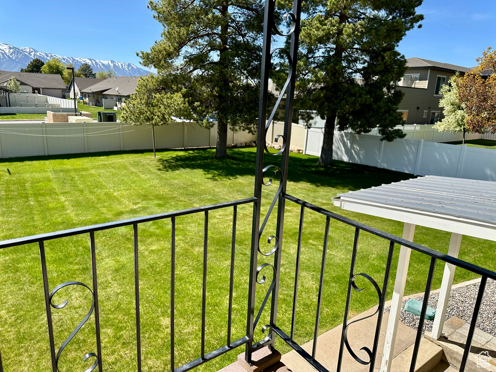 View of yard with fence, a residential view, and a mountain view