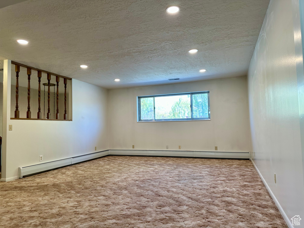 Carpeted spare room with baseboards, recessed lighting, and a textured ceiling