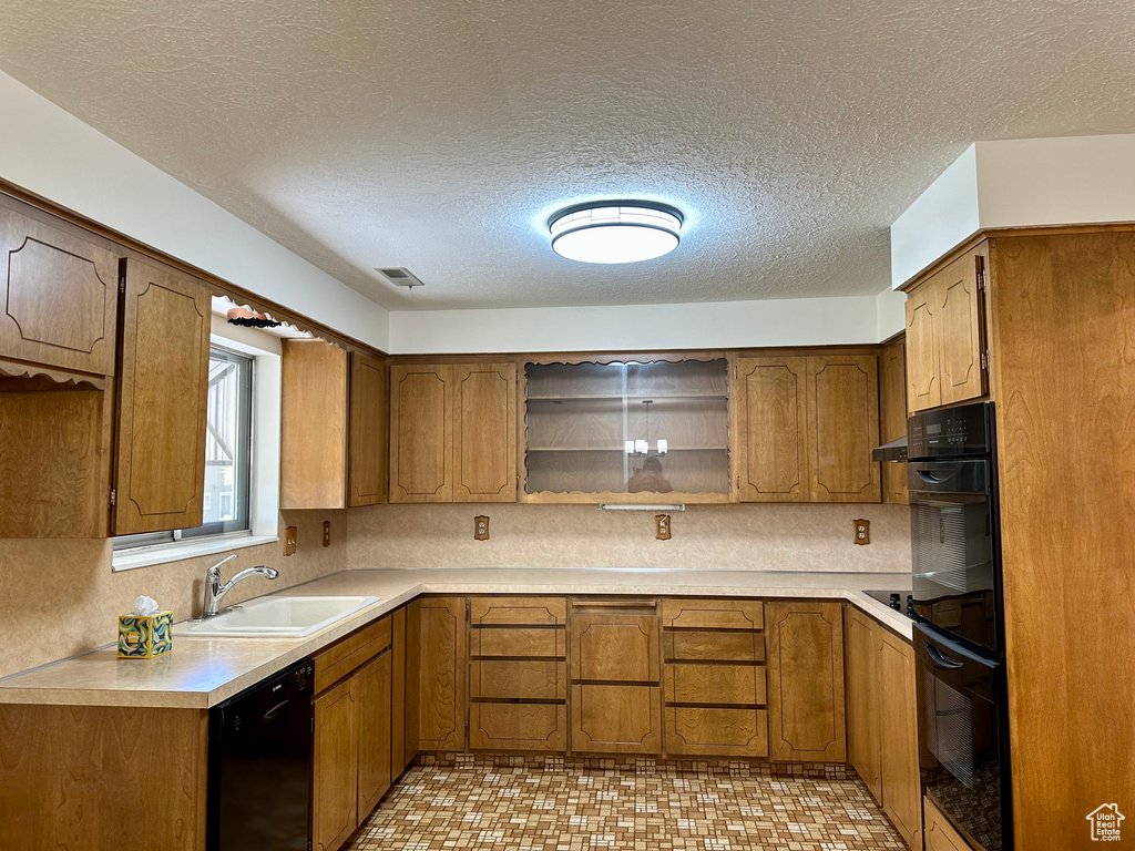 Kitchen with open shelves, brown cabinetry, a sink, and black appliances