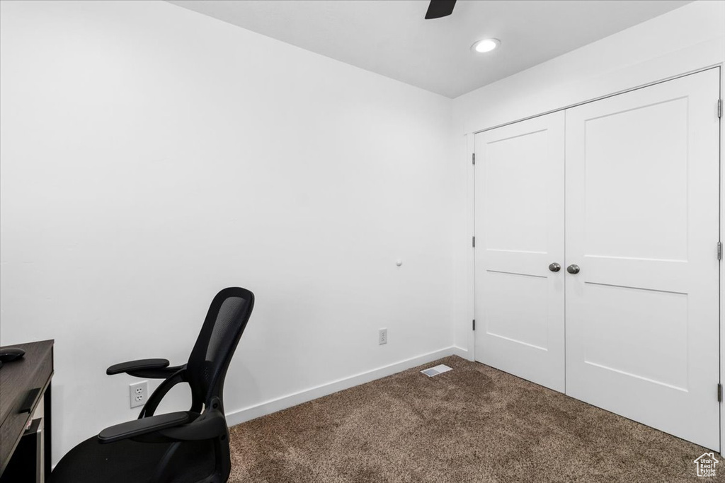 Unfurnished office with dark colored carpet, a ceiling fan, baseboards, and recessed lighting