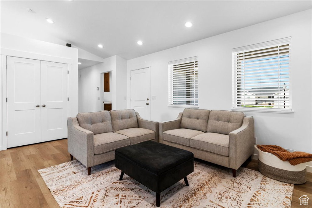 Living room with light wood-style floors, recessed lighting, and vaulted ceiling