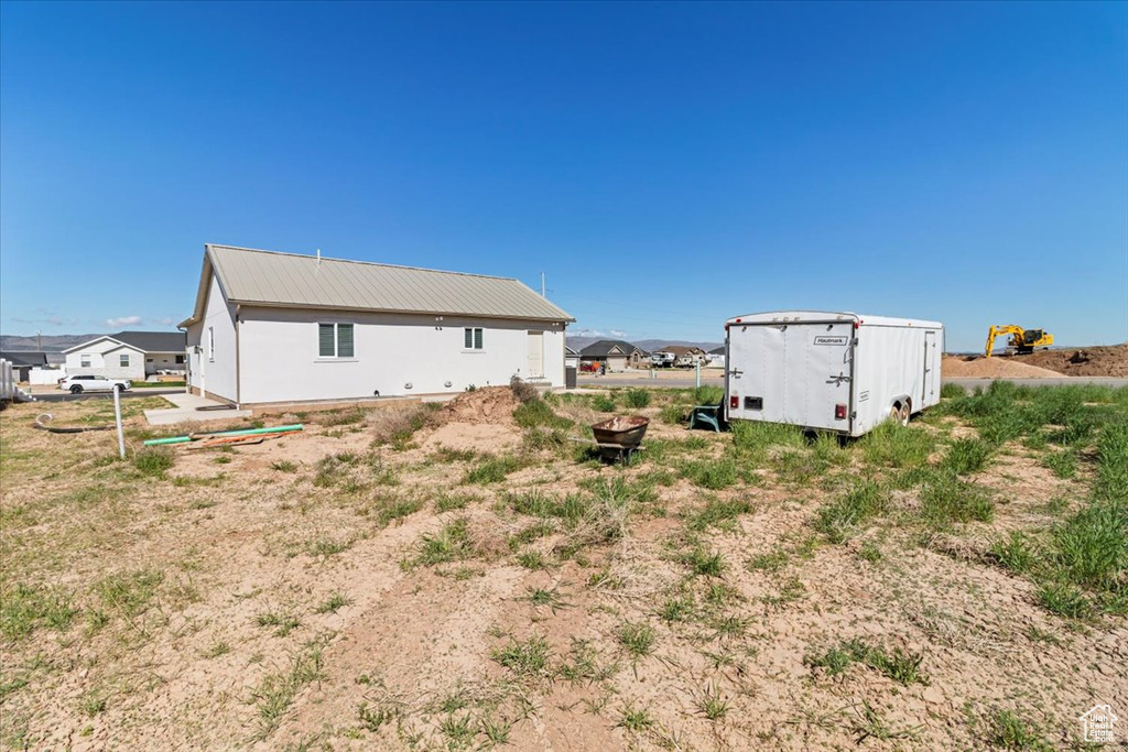 Rear view of property featuring metal roof and an outdoor structure