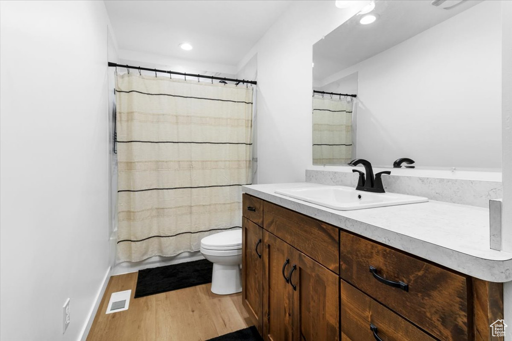 Bathroom with vanity, toilet, recessed lighting, wood finished floors, and visible vents