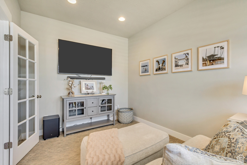 Carpeted living area with recessed lighting and baseboards