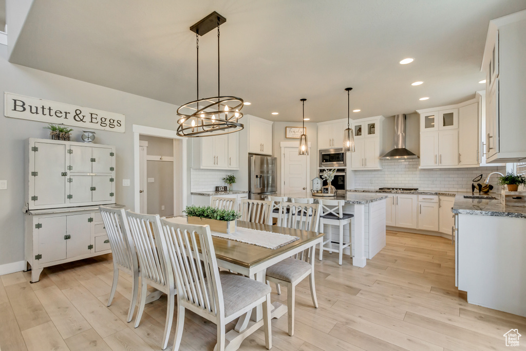 Dining space featuring recessed lighting, light wood-style flooring, and a notable chandelier