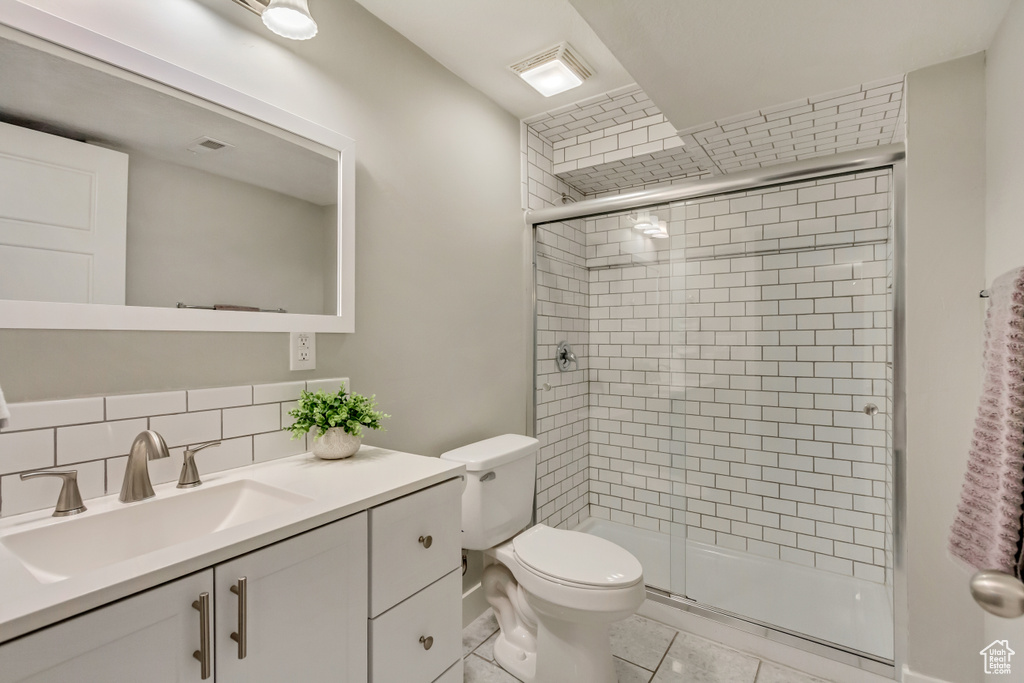 Full bath with vanity, tile patterned flooring, a shower stall, and toilet