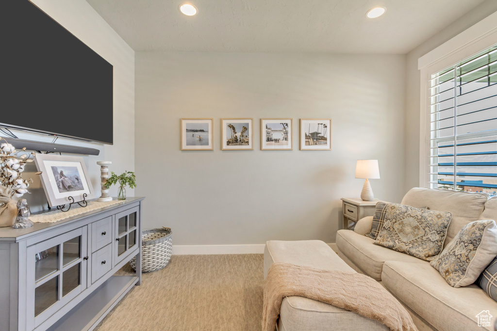 Living room with light colored carpet, recessed lighting, and baseboards