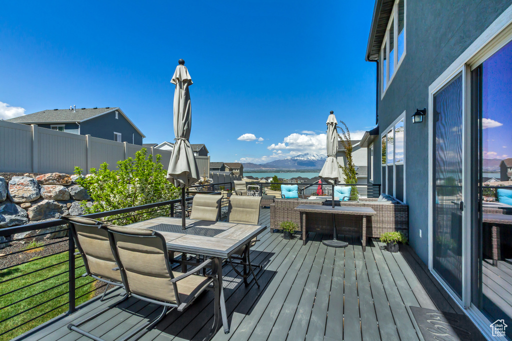 Deck with a water view and outdoor dining space