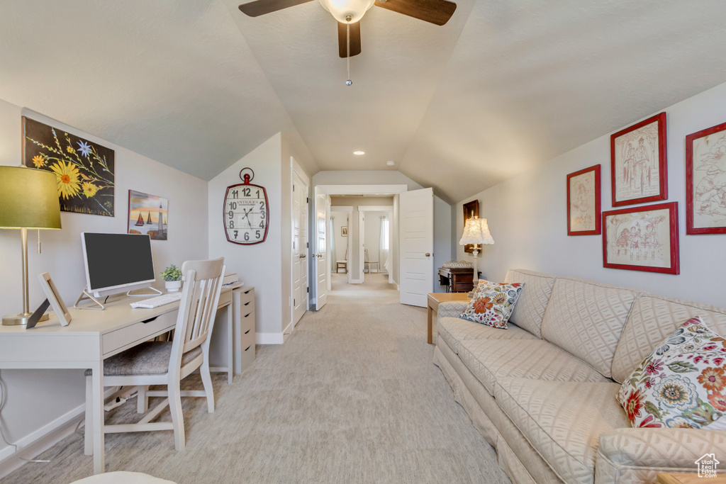 Office area with ceiling fan, light colored carpet, baseboards, and vaulted ceiling