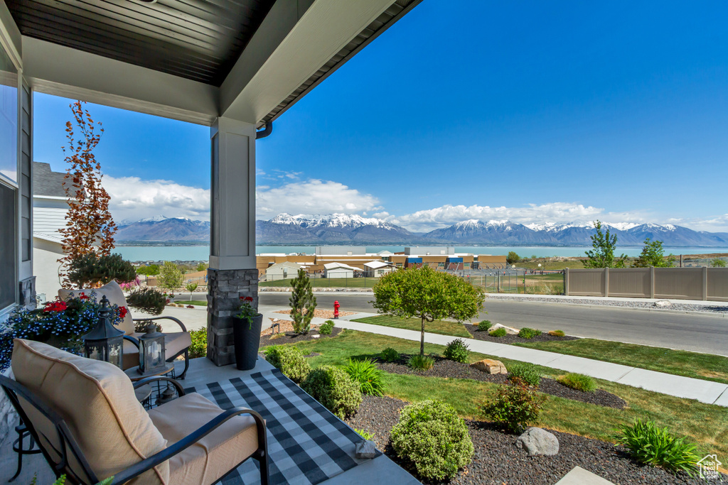 View of patio / terrace featuring fence, a mountain view, and a porch