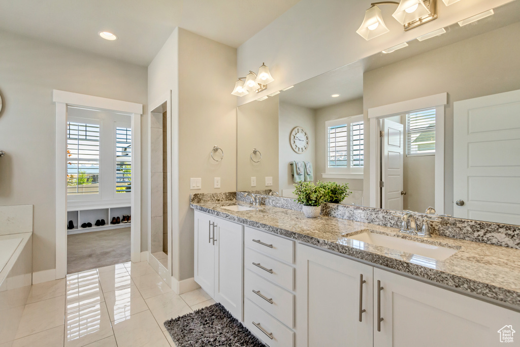 Bathroom with a sink, baseboards, and tile patterned floors