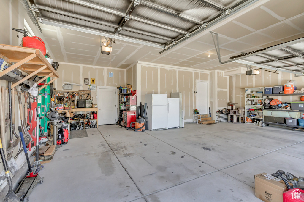 Garage with freestanding refrigerator and a garage door opener