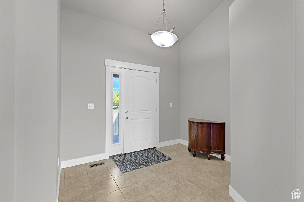 Entryway with baseboards, light tile patterned flooring, and visible vents