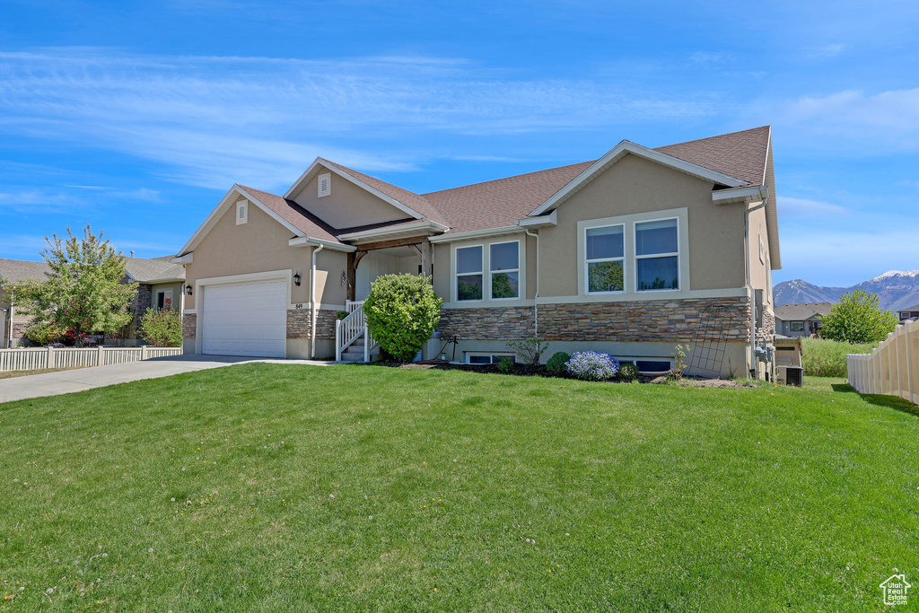 View of front of home with a garage, stucco siding, concrete driveway, and stone siding