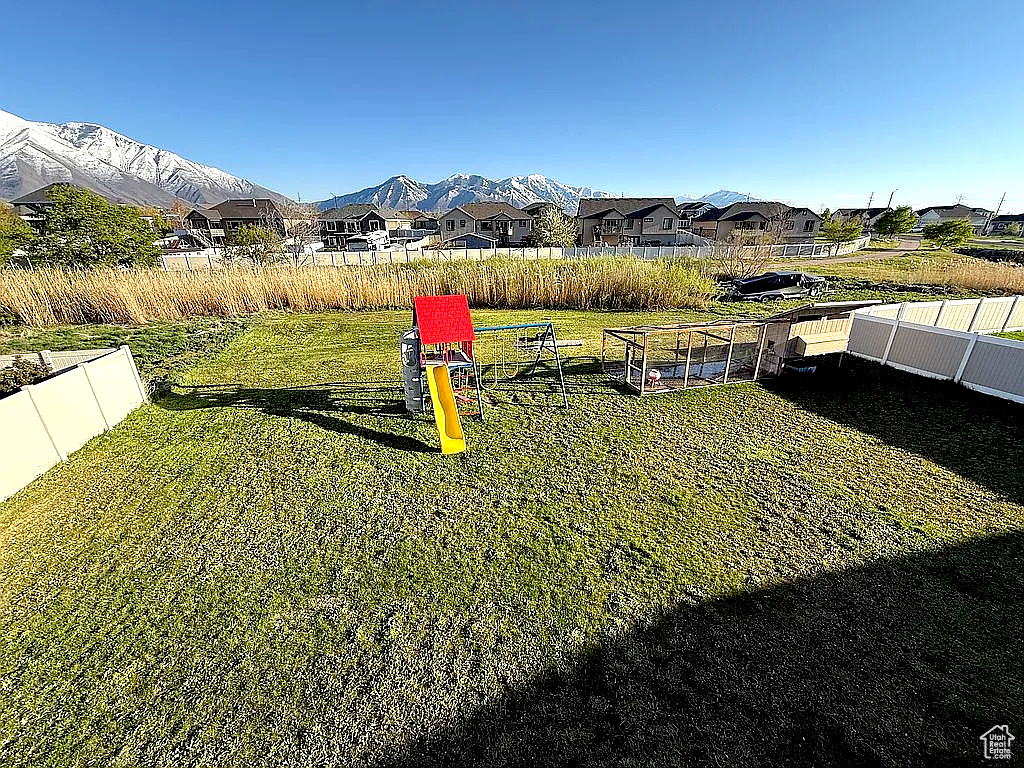 View of yard featuring a mountain view, fence, and a residential view
