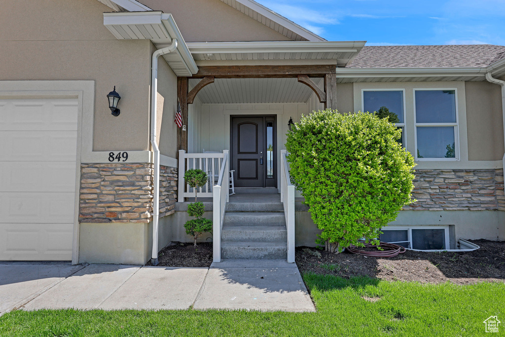 Property entrance featuring stucco siding and stone siding