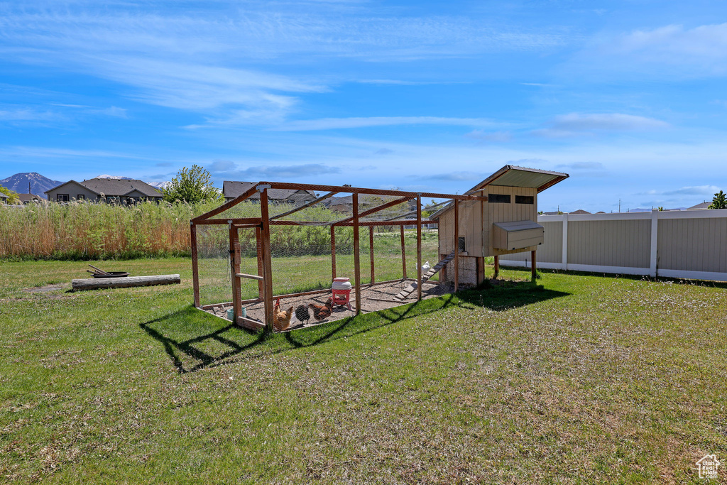 View of yard with fence, exterior structure, and an outbuilding