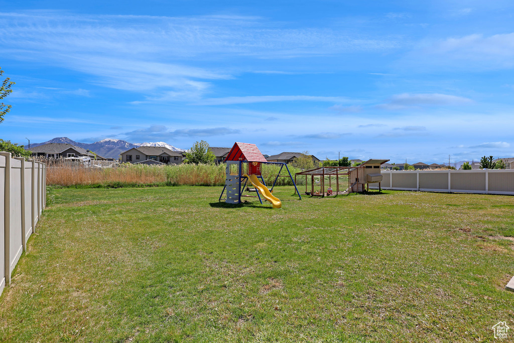 View of yard featuring fence and a playground