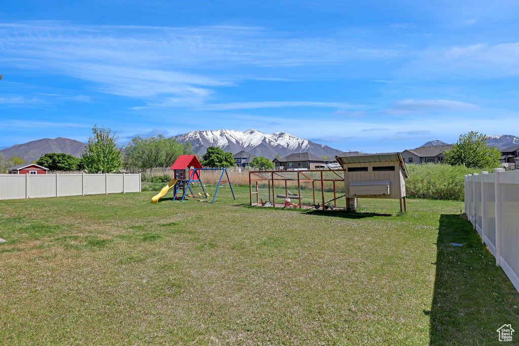 View of yard with fence, exterior structure, and a mountain view