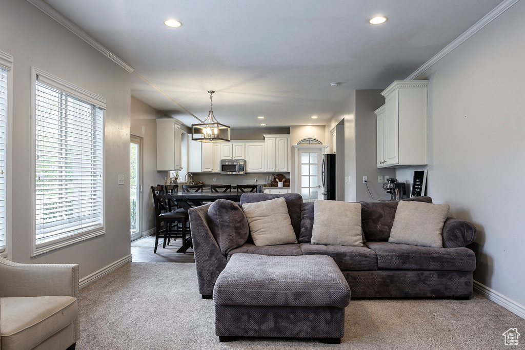 Carpeted living room featuring baseboards, ornamental molding, and recessed lighting