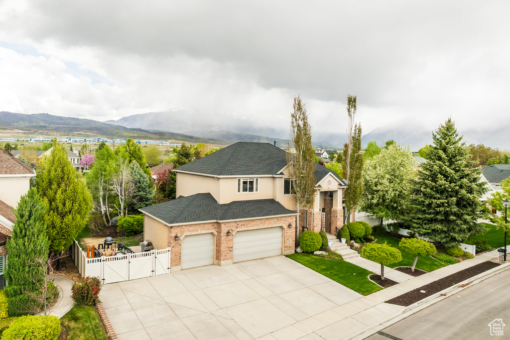 Traditional-style home featuring fence, a garage, stucco siding, a gate, and concrete driveway