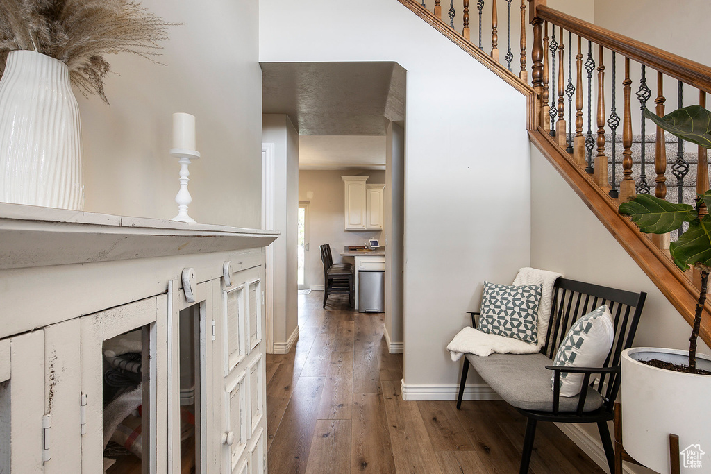 Interior space featuring baseboards, hardwood / wood-style flooring, and a towering ceiling