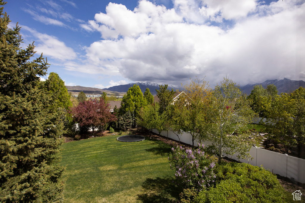 View of yard with a mountain view and fence
