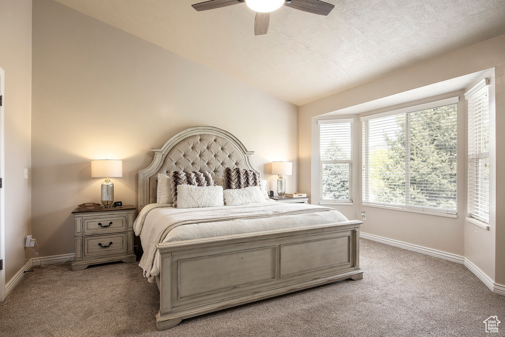 Bedroom featuring baseboards, a ceiling fan, lofted ceiling, and light carpet