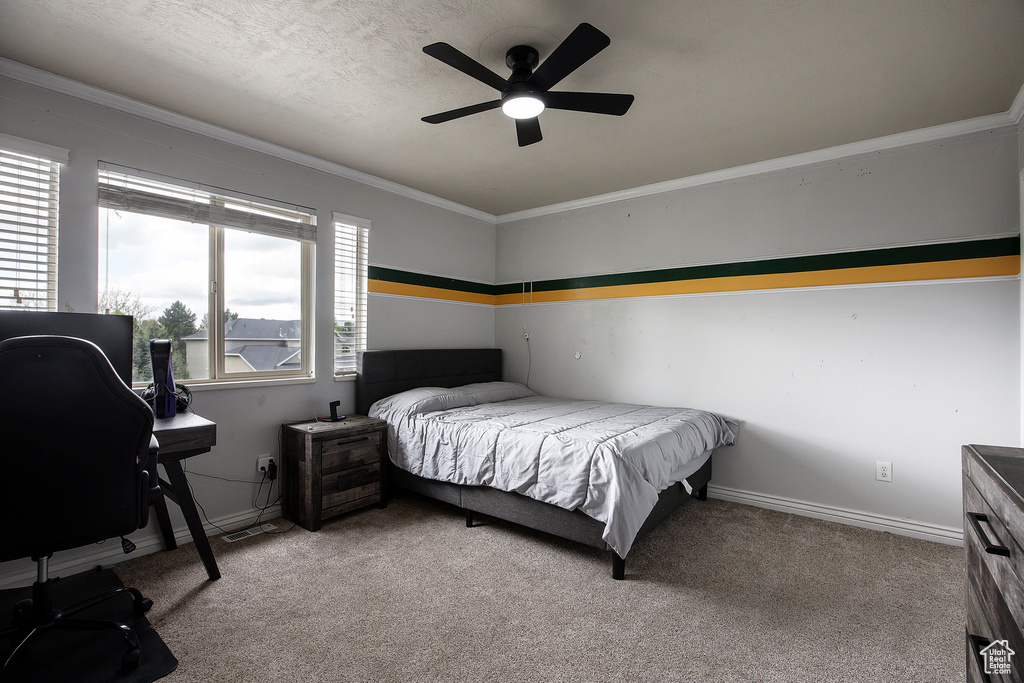 Carpeted bedroom featuring a ceiling fan, baseboards, and ornamental molding
