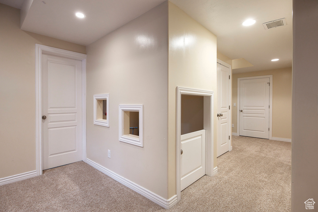 Corridor featuring recessed lighting, light colored carpet, and visible vents