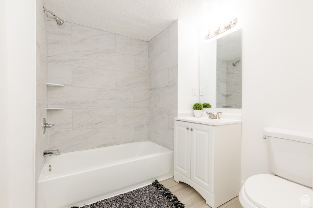 Bathroom featuring toilet, tub / shower combination, and vanity