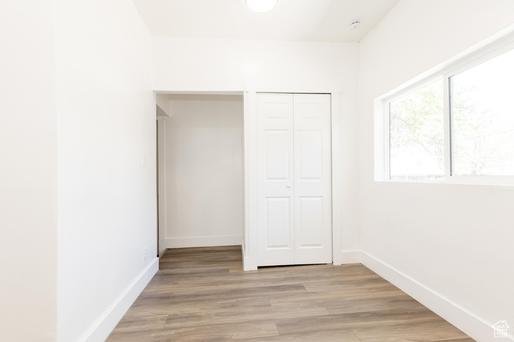 Unfurnished bedroom with baseboards, light wood-type flooring, and a closet